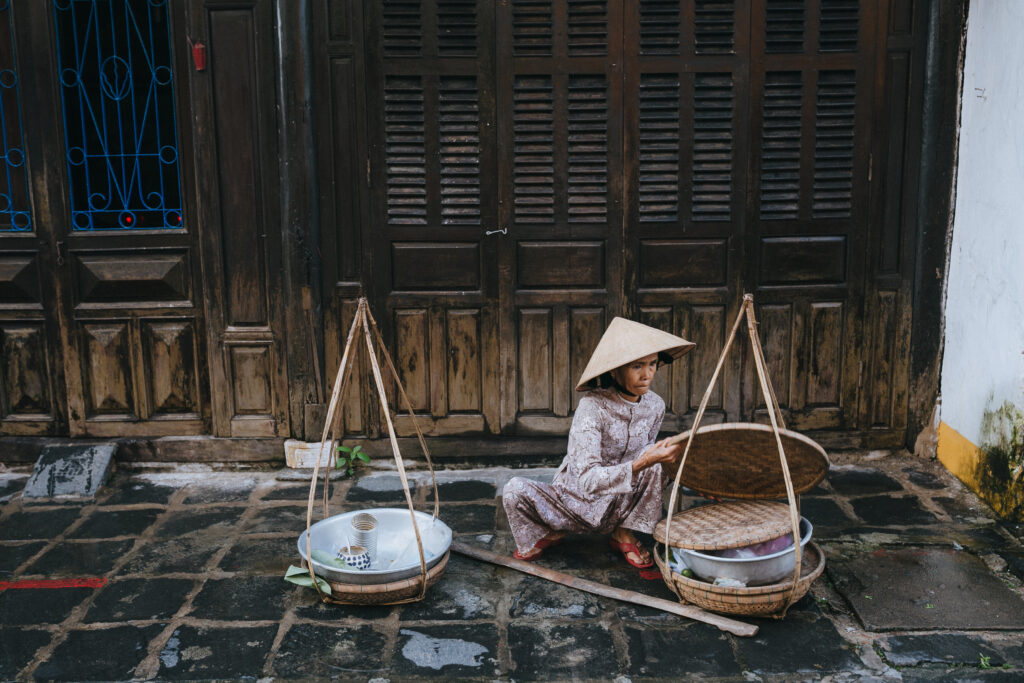 HOI AN, VIETNAM - 03 JANUARY, 2018: senior vietnamese woman selling food on street in Hoi An,