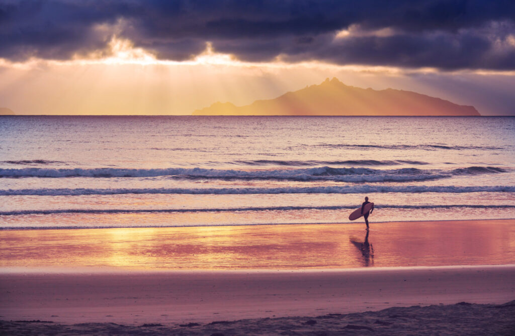 surfers on ocean  beach in New Zealand
